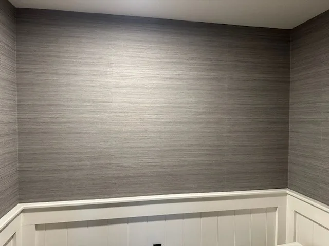 Dark navy botanical wallpaper on a bedroom feature wall with pendant lighting