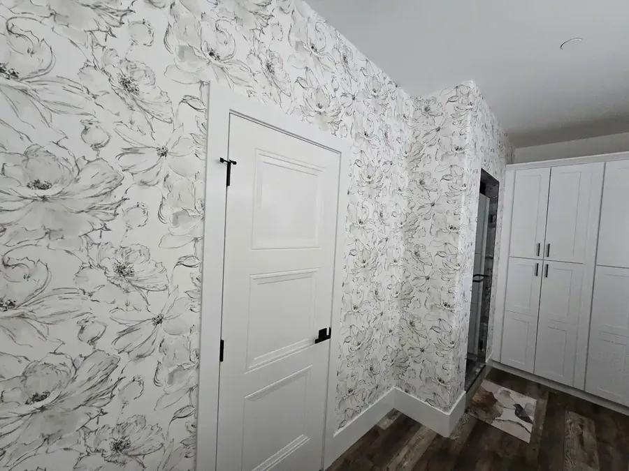 Room mid-renovation with walls stripped and skim coated during wallpaper removal